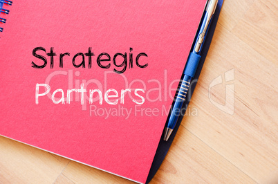 Strategic partners write on notebook