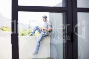 Man sitting on terrace using digital tablet