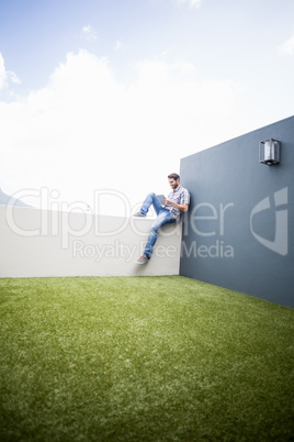 Man sitting on terrace using digital tablet