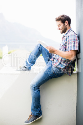 Man sitting on terrace using digital tablet