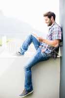 Man sitting on terrace using digital tablet