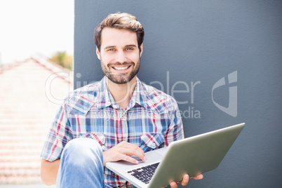 Man sitting on terrace using laptop