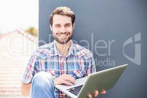 Man sitting on terrace using laptop