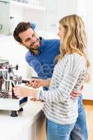 Young couple preparing coffee from coffeemaker