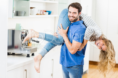 Man lifting his woman in kitchen
