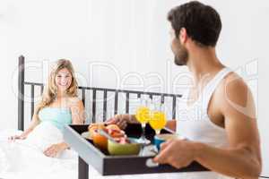 Man serving breakfast to woman