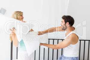 Young couple having a pillow fight