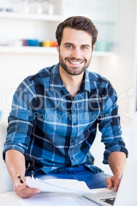 Young man paying his bill online with laptop