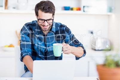 Man using laptop while having coffee