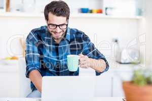 Man using laptop while having coffee