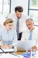 Business colleagues discussing office work on laptop