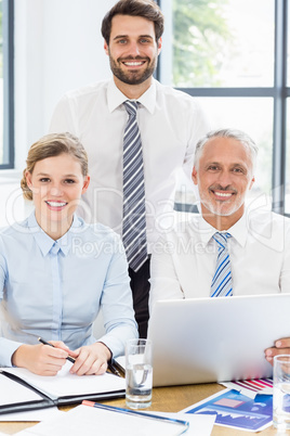 Portrait of happy business colleagues working at desk