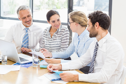 Business colleagues discussing office work on laptop