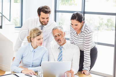 Business colleagues discussing office work on laptop