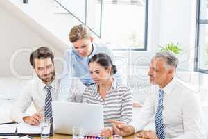 Business colleagues discussing office work on laptop