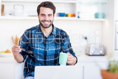 A man is holding his glasses and a mug