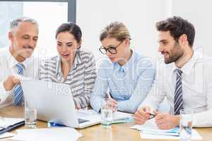 Business colleagues discussing office work on laptop