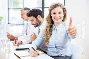 Portrait of businesswoman showing thumbs up