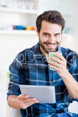 Man using digital tablet while having coffee