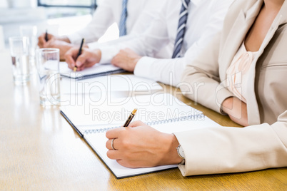 A Mid section of business colleagues is writing in a diary A Mid section of business colleagues is writing in a diary