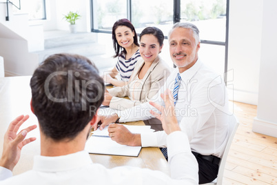 Workers are listening another worker and smiling