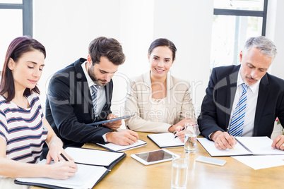 Workers are reading their notes and one is smiling