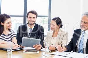 Workers are looking at a notebook and one of them is looking in