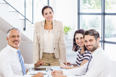 A businesswoman is talking to her colleagues who are listening t