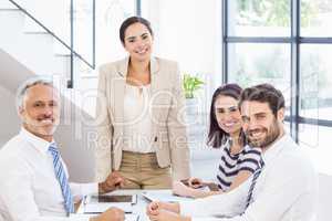 A businesswoman is talking to her colleagues who are listening t