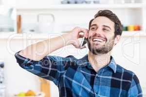 A man is talking on the phone and smiling