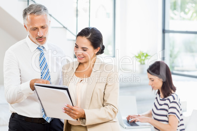 Businessman and businesswoman looking at diary