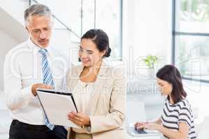 Businessman and businesswoman looking at diary