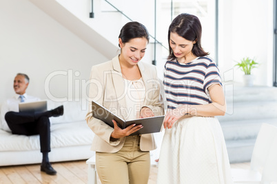 Businesswoman and a colleague looking at diary