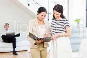 Businesswoman and a colleague looking at diary
