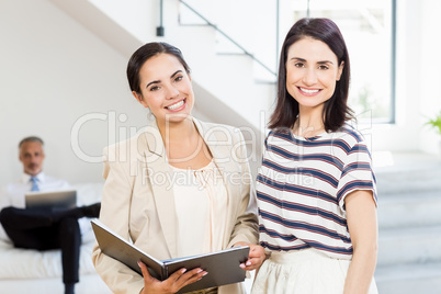 Businesswoman and a colleague holding diary