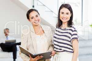 Businesswoman and a colleague holding diary