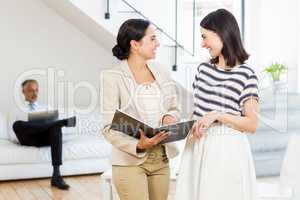 Businesswoman and a colleague interacting and holding diary