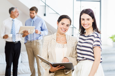 Businesswoman and a colleague smiling at camera