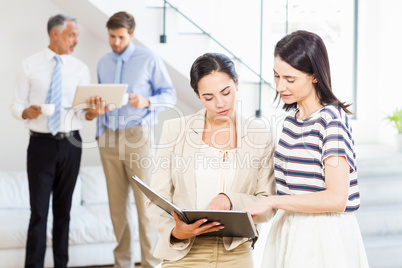 Businesswoman and a colleague looking at diary