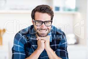 Young man in spectacles smiling at camera