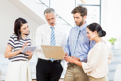 Business people interacting using digital tablet and laptop