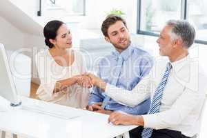 Businessman shaking hands with businesswoman in meeting