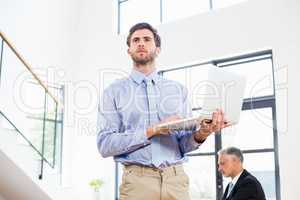 Thoughtful businessman using laptop