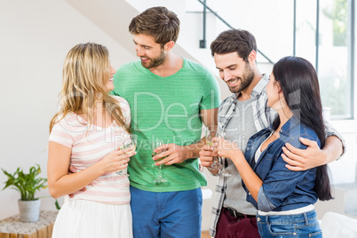 Two cute couple smiling with alcohol glass in hand