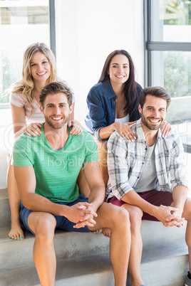 Two cute couple smiling sitting on sofa