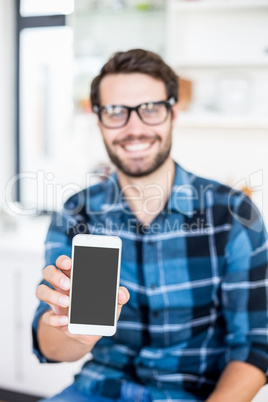 Cute hipster with glasses showing smartphone screen
