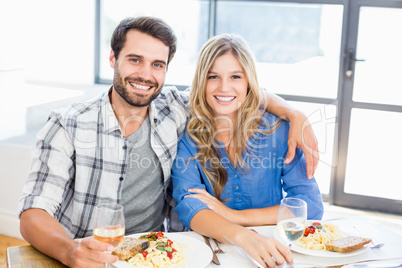 Portrait of young couple sitting together while having meal