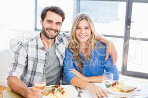 Portrait of young couple sitting together while having meal