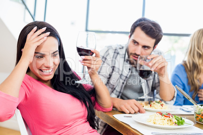 Man looking drunk woman with wine glass