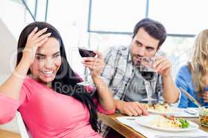 Man looking drunk woman with wine glass
